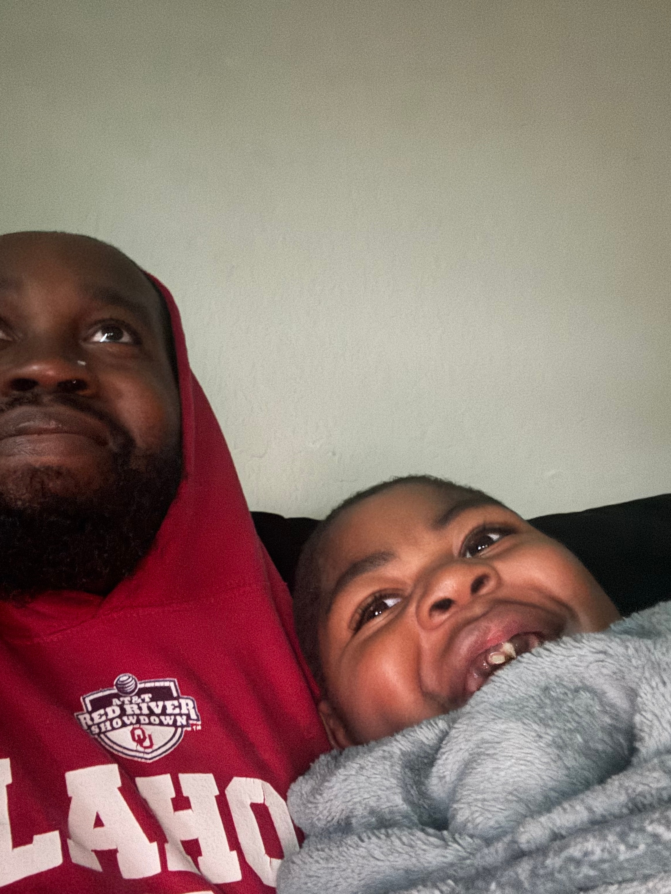 George and Myles relaxing together on the couch, Myles smiling up